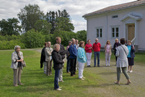 Voipaalan pihalla kuuntelemassa opastusta Voipaalan ja Rapolan historiasta